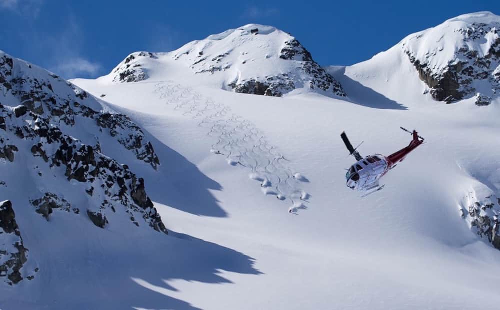 helicopter dropping off skiers